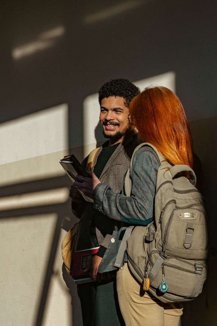 Two students having a light chat in a sunlit hallway, Buenos Aires.